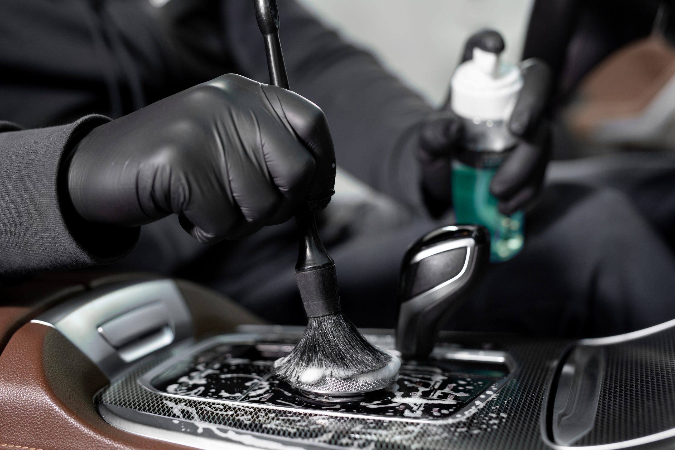 process of applying foam and detergent with a brush. a car wash service worker cleans the car inside